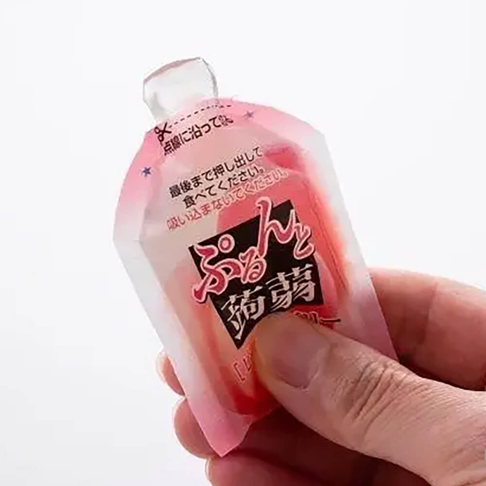 Одна открытая конфета из желе конняку ORIHIRO Purunto Konnyaku Jelly Pouch в руке человека