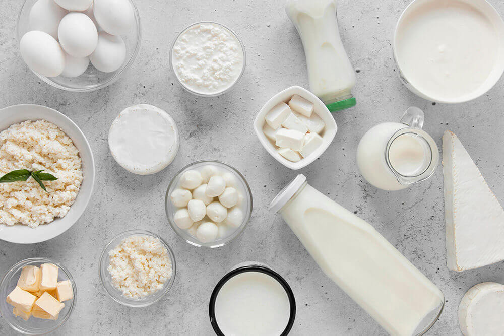 Різні молочні продукти на столі в посуді. Вид зверху.