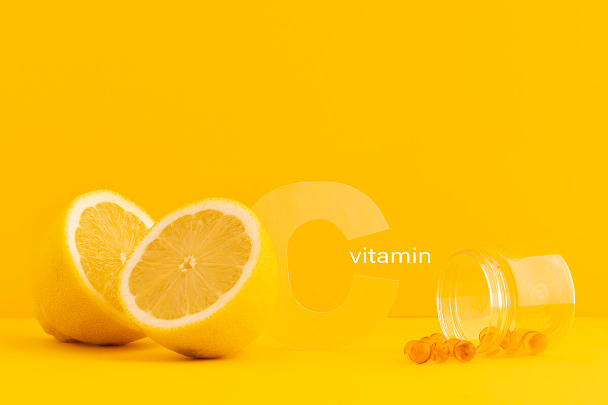 Малюнок: апельсини та капсули з вітаміном С з написом латиницею vitamin C
