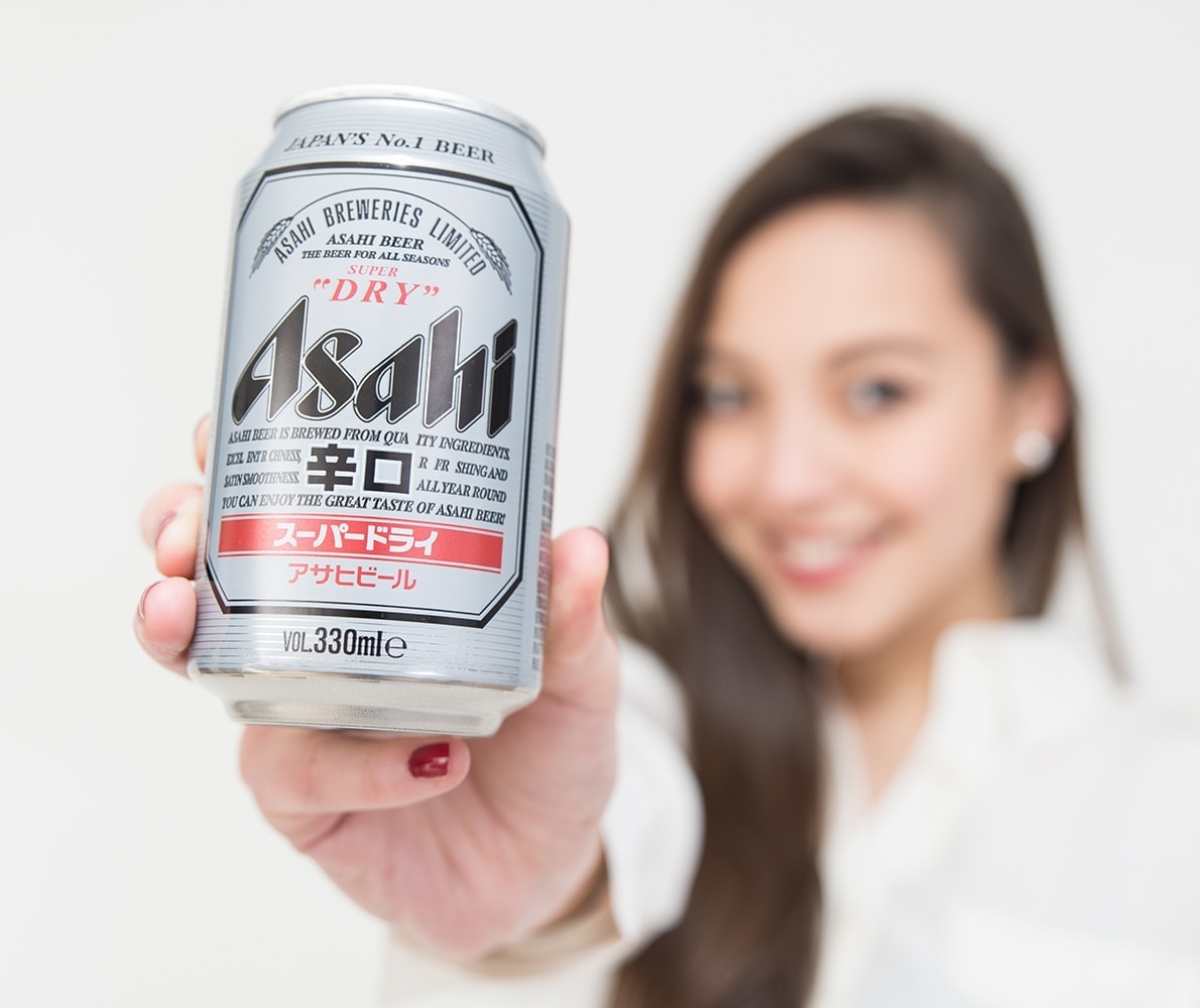 Японская девушка, которая держит в руке банку пива Asahi Super Dry
