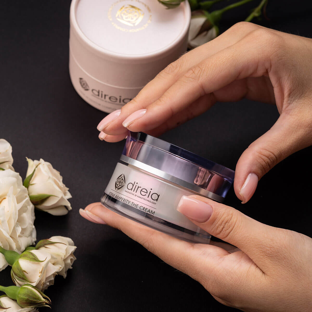 Закрита банка DIREIA Stem Amperity The Cream в красивих жіночих руках на тлі білих троянд