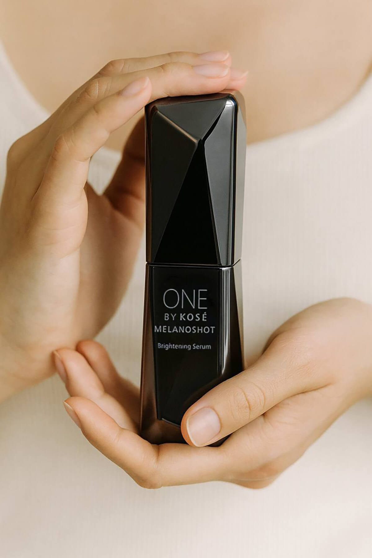 Флакон із сироваткою ONE BY KOSE Melanoshot W Brightening Serum в доглянутих жіночих руках
