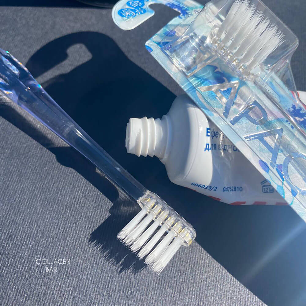 Чистяча головка іонної зубної щітки APAGARD 'Crystal' Toothbrush і відкритий тюбик зубної пасти крупним планом