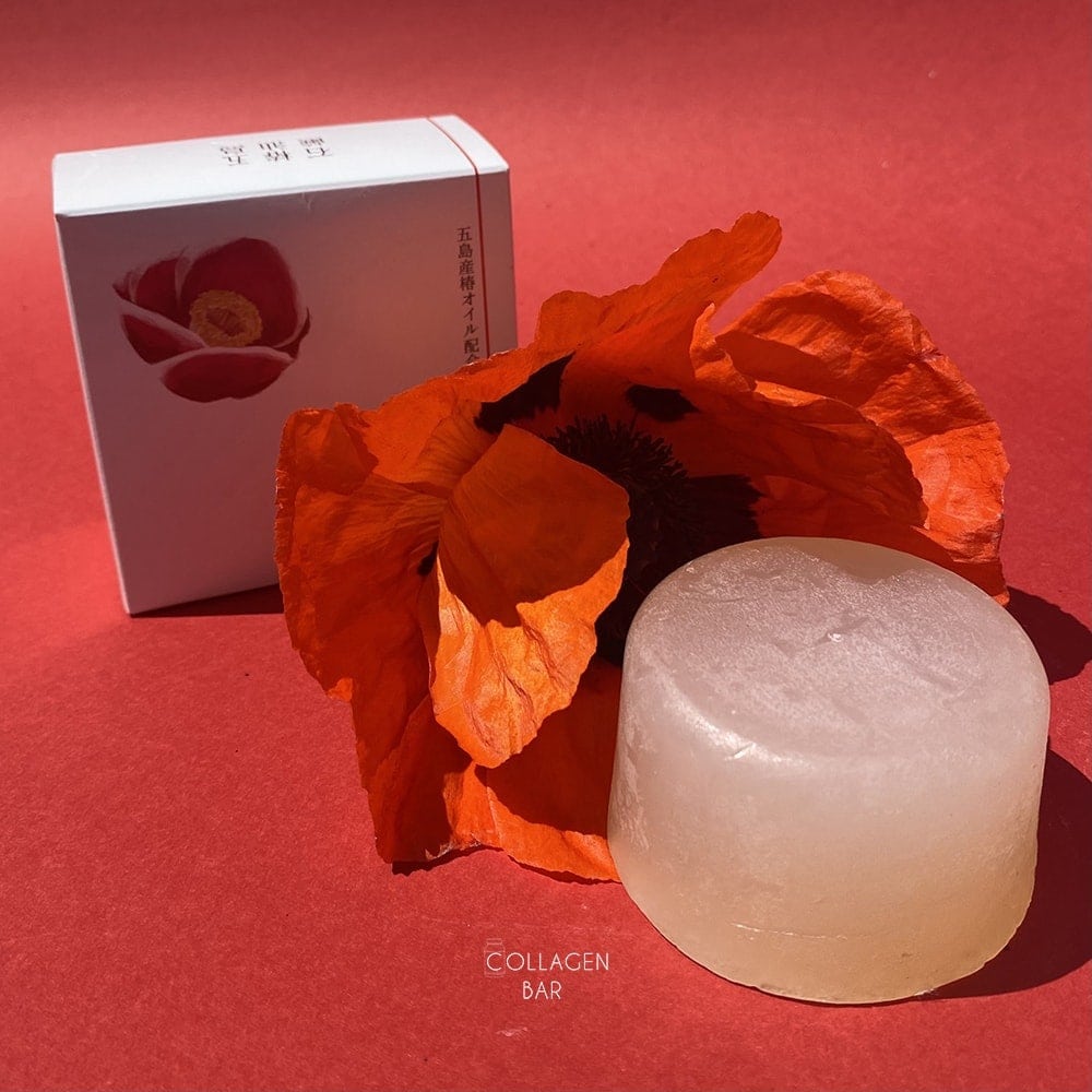 Мыло Goto Camellia Oil Soap и большой цветок красного мака на красном фоне