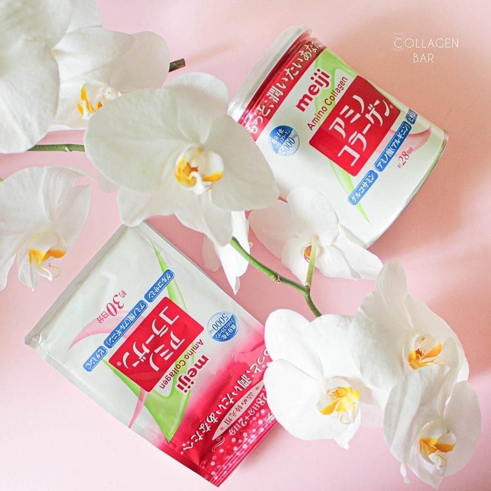 Змінний пакет і банку колагену Meiji Amino Collagen на рожевому фоні та квіти білої орхідеї посередині