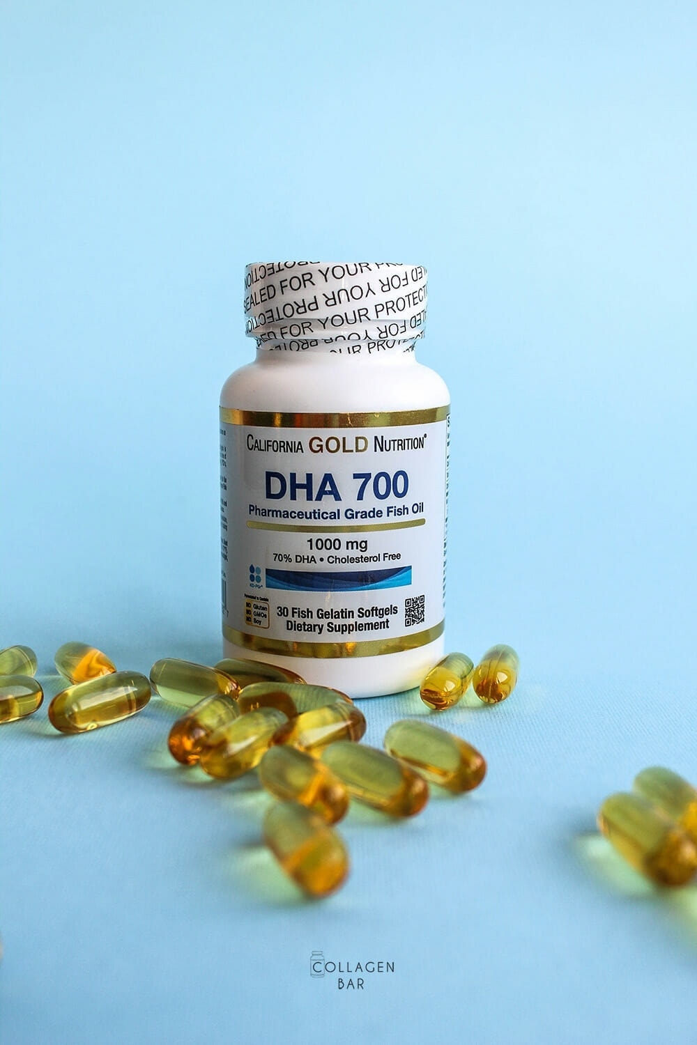 Банка DHA-700 от California Gold Nutrition на синем фоне и капсулы рядом