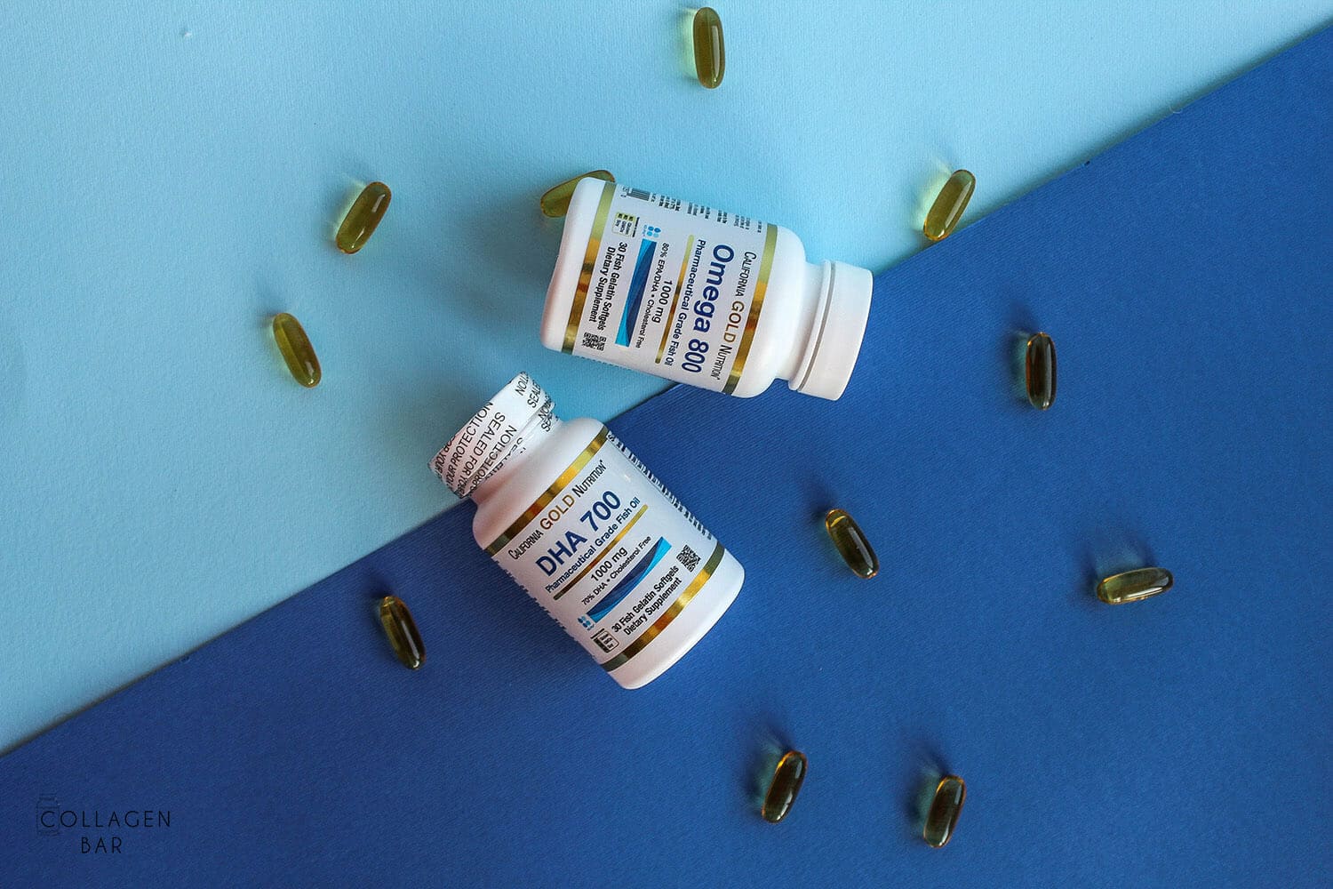 Банки с Omega-800 и DHA-700 от California Gold Nutrition на синем фоне и капсулы рядом