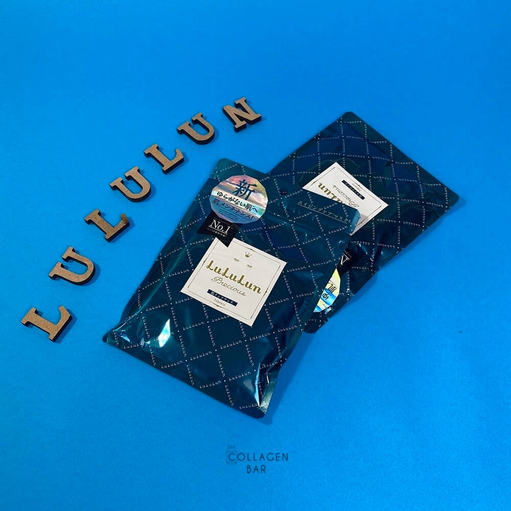 Дві упаковки масок LuLuLun Precious Green по 7 штук і слово LULULUN, викладене дерев'яними літерами