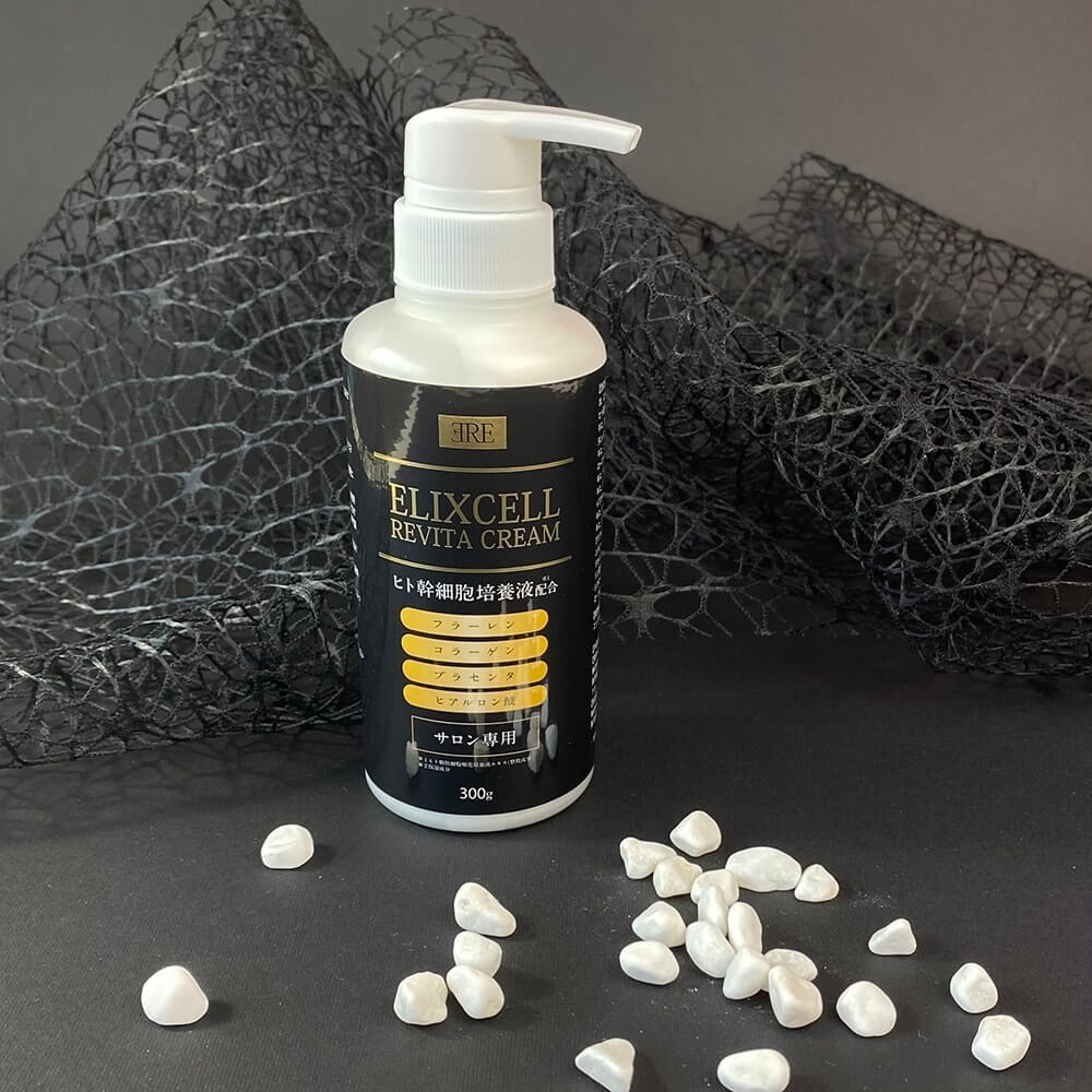 Крем Elixcell Revita Cream на тлі чорної декоративної сіточки з дрібними білими камінчиками на чорному тлі