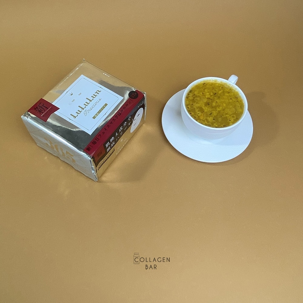 Маска LuLuLun Precious WHITE і чашка обліпихового чаю на світло-жовтому тлі