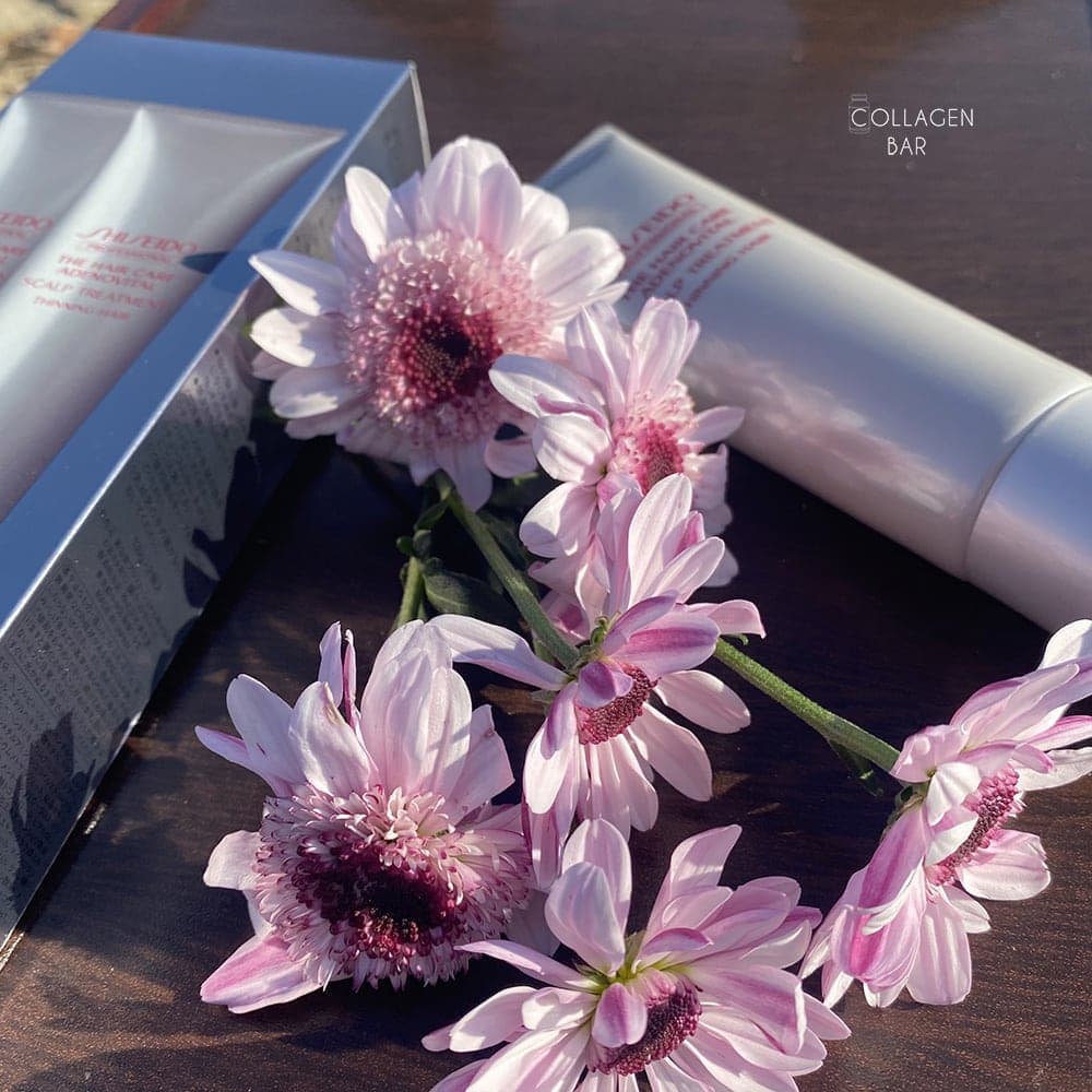 Бальзам для кожи головы SHISEIDO ADENOVITAL на деревянной поверхности с фиолетовыми цветами