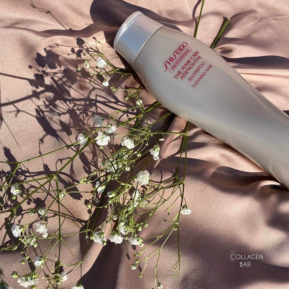 Шампунь SHISEIDO ADENOVITAL на светло-коричневой ткане с веточкой с маленькими белыми цветками