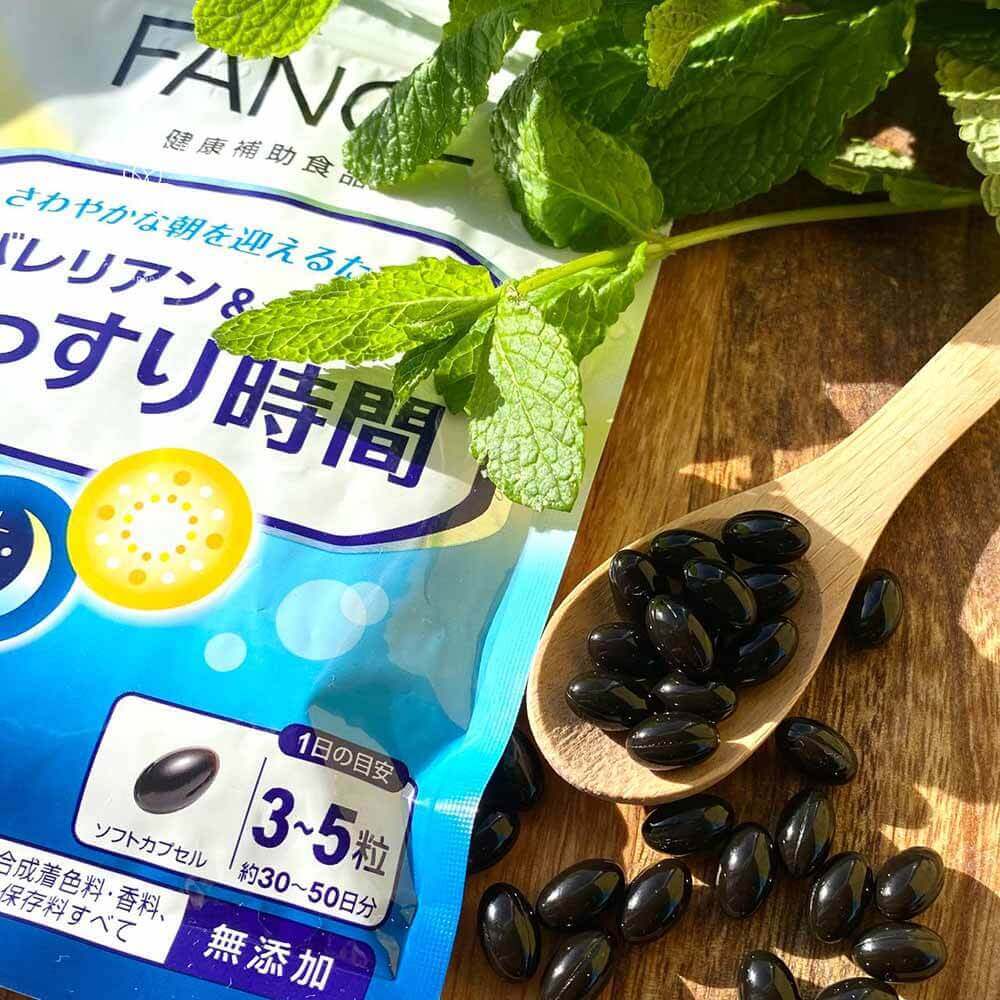 Капсули комплексу Fancl Natural Sleep у дерев'яній ложці на тлі цілої упаковки
