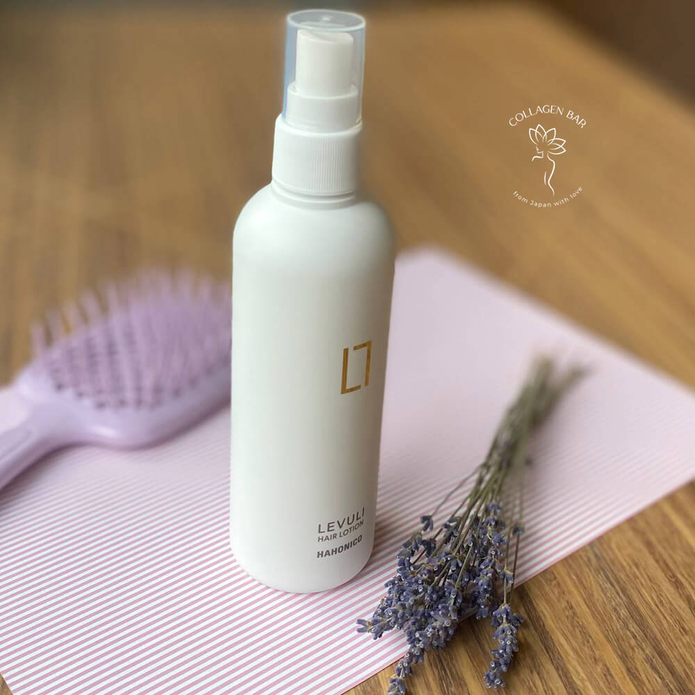 Лосьйон HAHONICO Levuli Hair Lotion вертикально з букетиком лаванди і щіткою для волосся в розфокусі