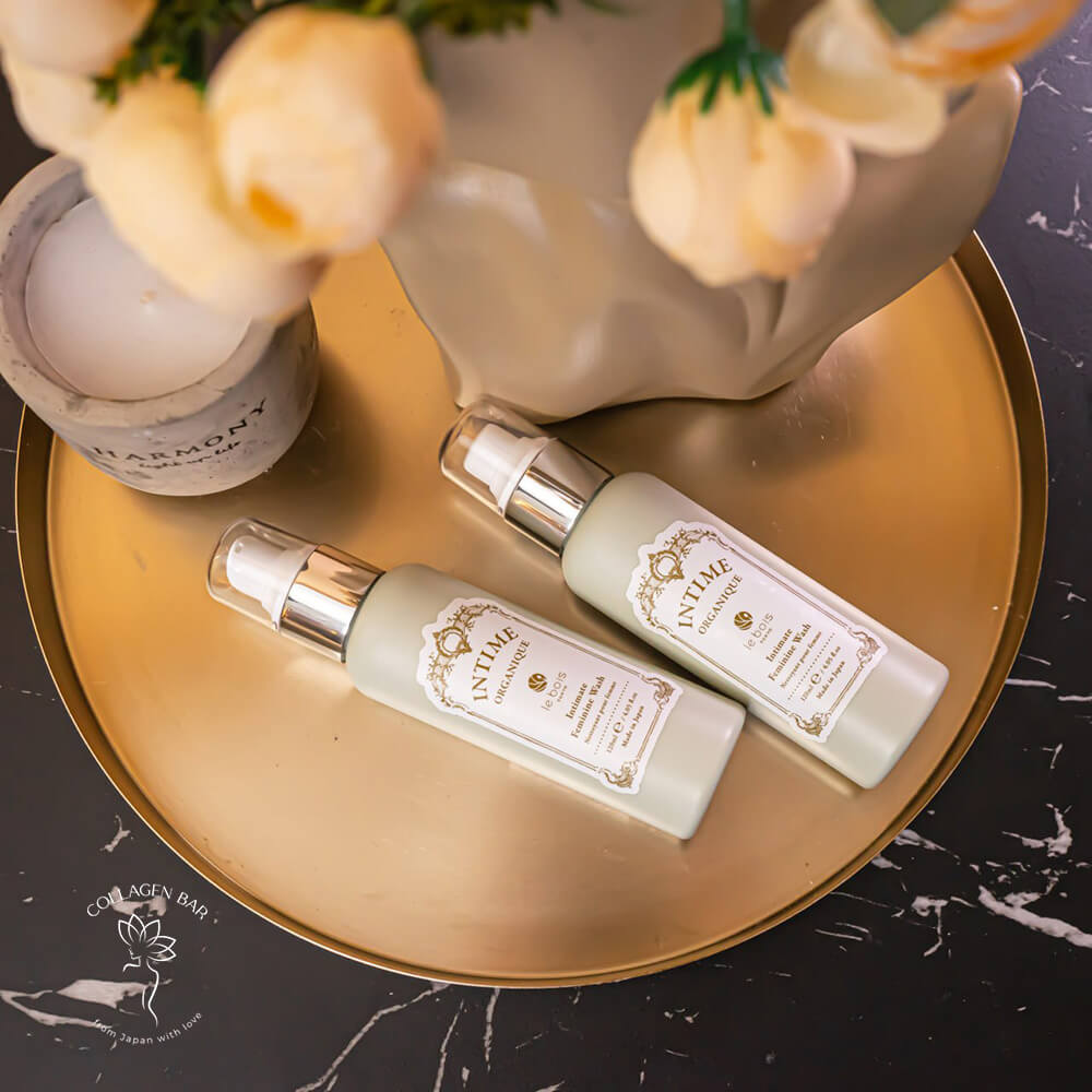 Два флакони Intime Organique Intimate Feminine Wash і жіноча голова-скульптура, прикрашена квітами. Вид зверху.