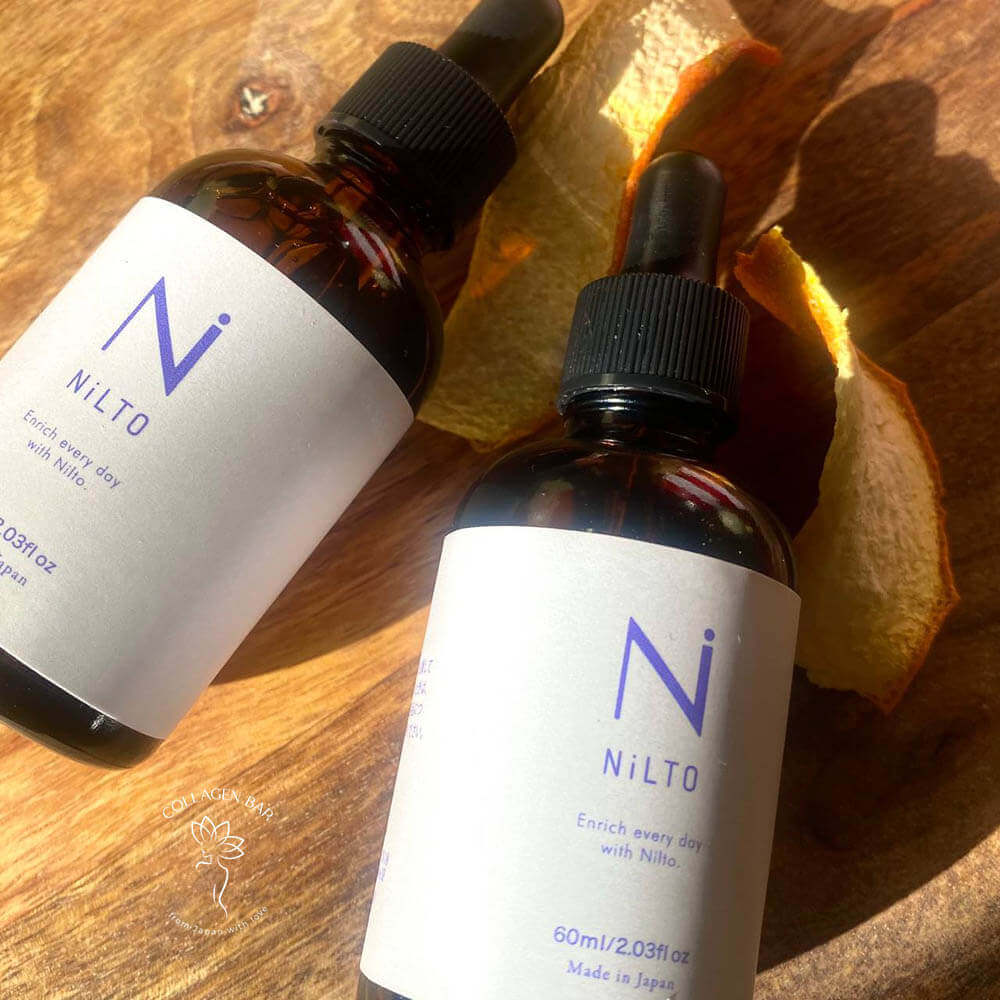 2 закритих флакони сироватки NILTO SKIN CARE SERUM на дерев'яній поверхні