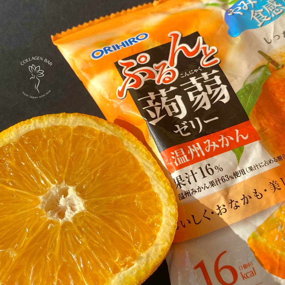 Упаковка конфет ORIHIRO Purunto Konnyaku Jelly Pouch Satsuma Mikan и половинка разрезанного мандарина