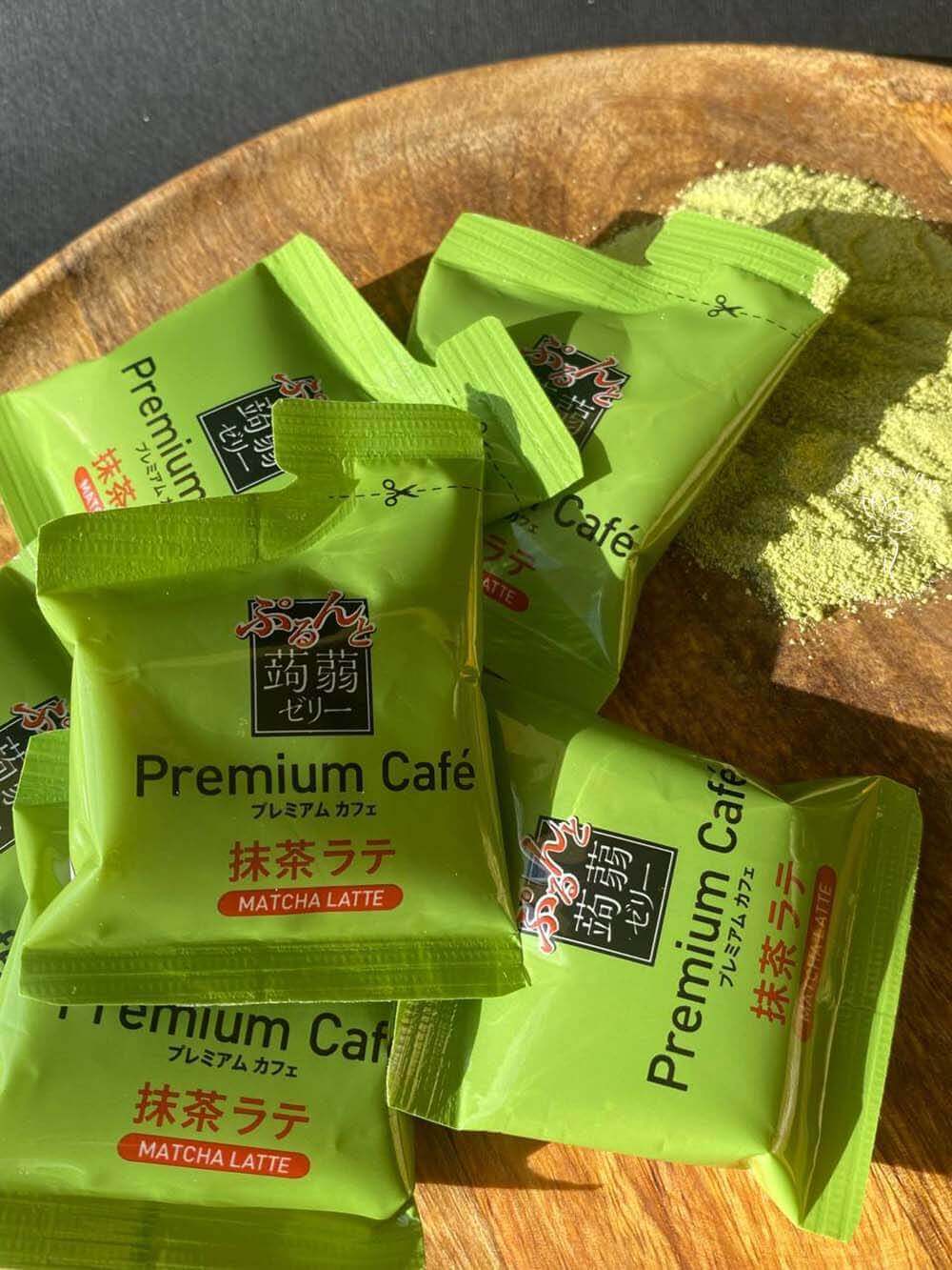 Множество конфет из конняку ORIHIRO Purunto Konnyaku Jelly Premium Cafe Matcha Latte со вкусом матча-латте на деревянном блюде с порошком маття
