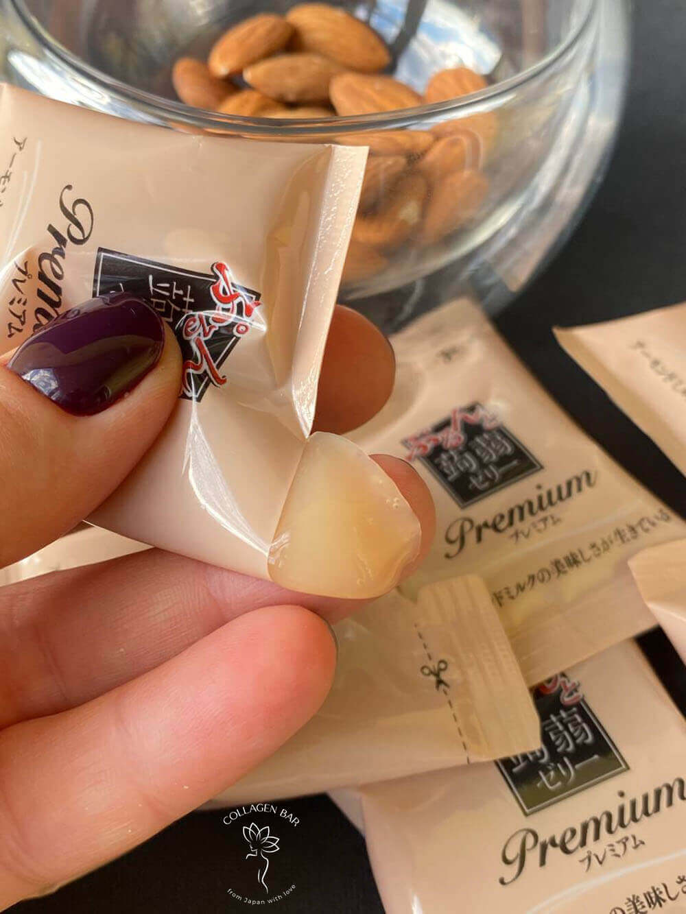 ORIHIRO Purunto Konnyaku Jelly Premium Cafe Almond Milk в индивидуальной упаковке в женской руке с бордовым маникюром