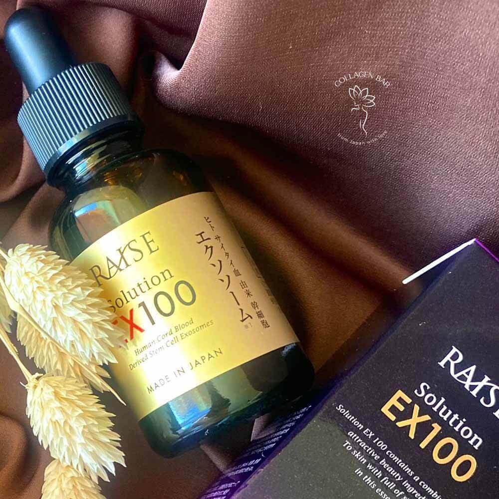Флакон і коробка сироватки з екзосомами RAISE Solution EX 100 на коричневій тканині з сухими колосками