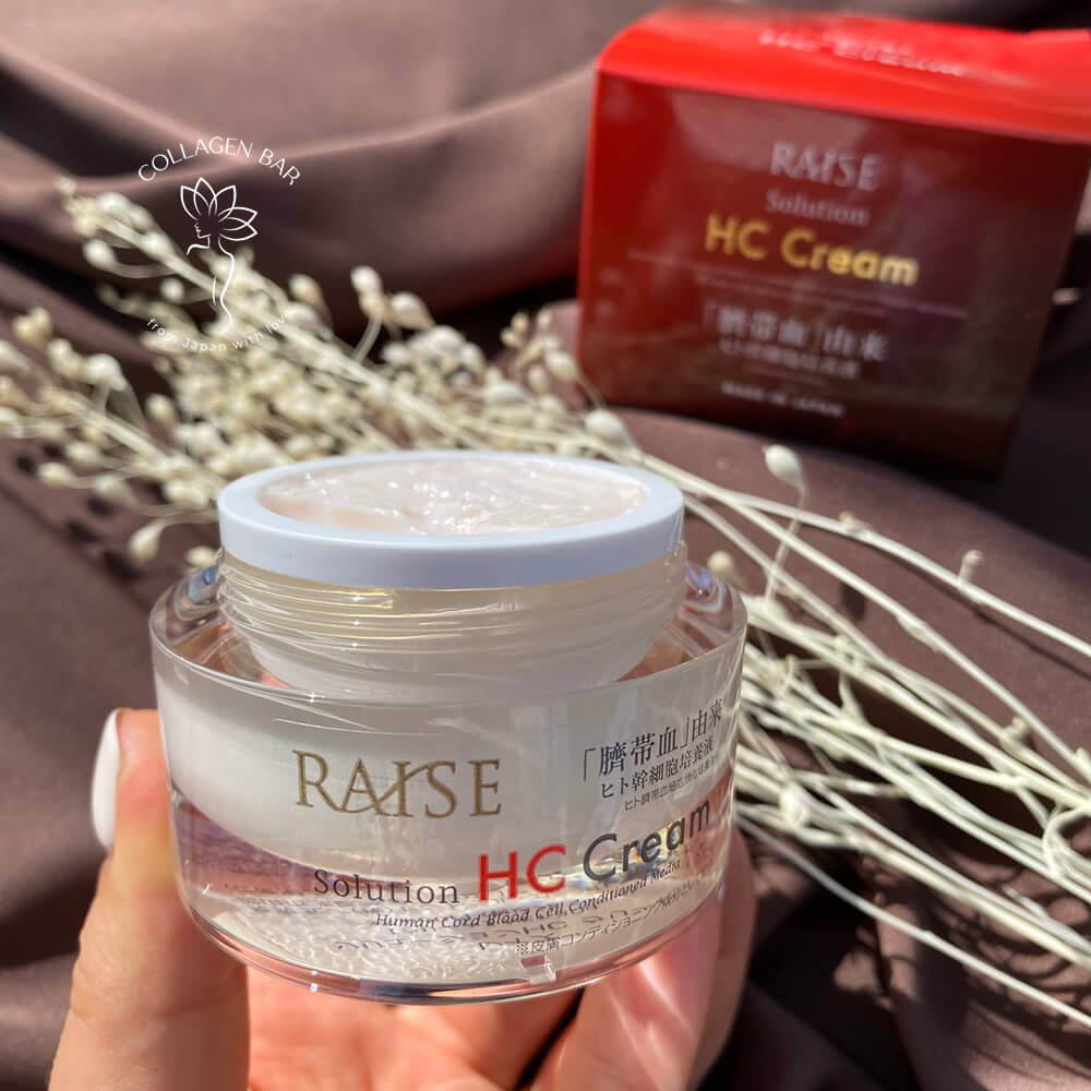 Відкрита баночка крему RAISE Solution HC Cream у жіночій руці з білим манікюром