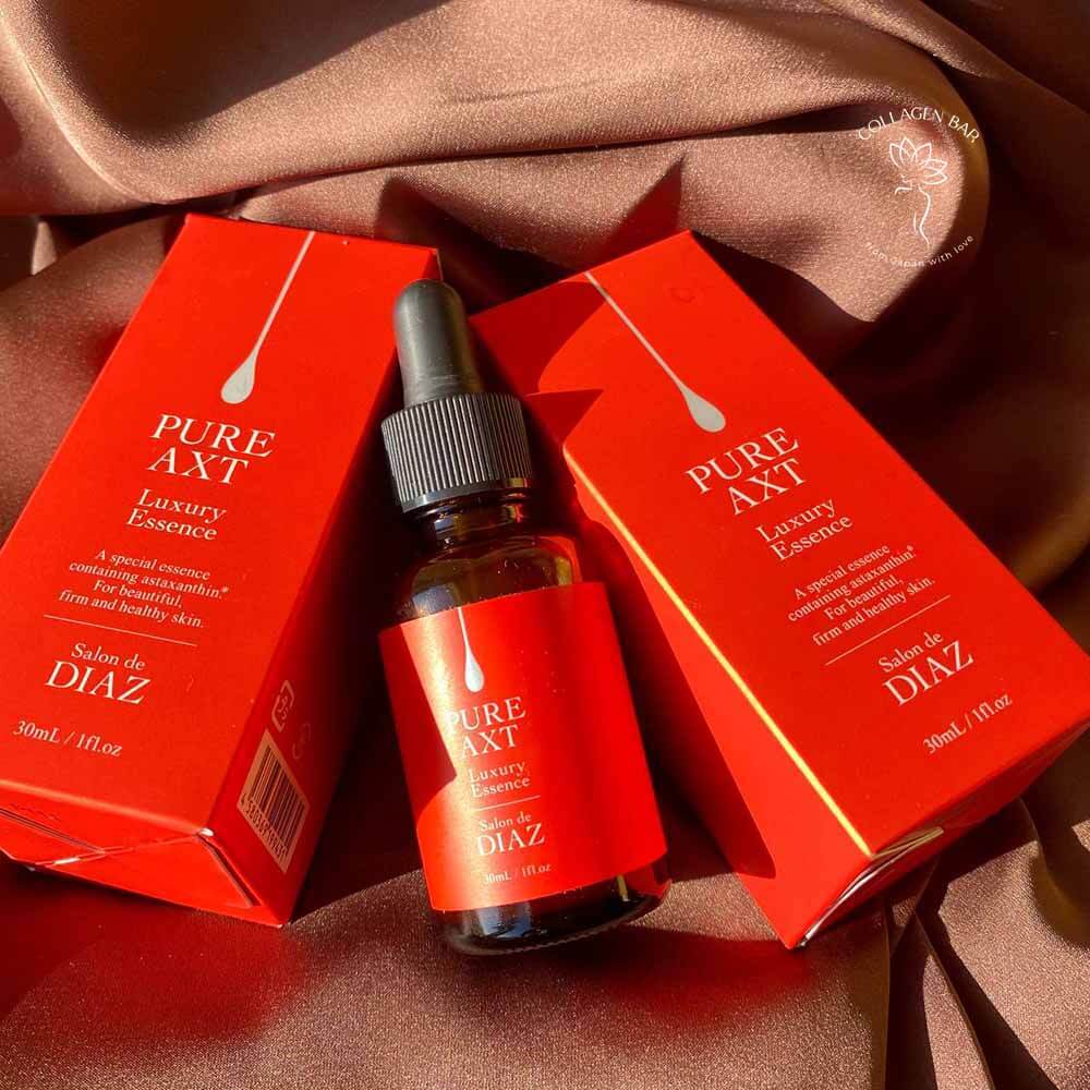 Флакон і дві коробки сироватки SALON DE DIAZ Pure AXT Luxury Essence на коричневій тканині
