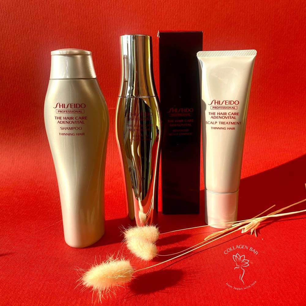 Всі продукти серії Shiseido Adenovital: шампунь, бальзам і лікувальна есенція на червоному тлі в положенні вертикально
