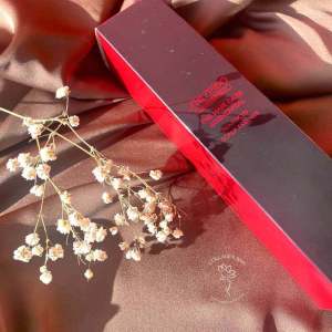 Коробка SHISEIDO Adenovital Advanced Scalp Essence з гілочкою сухих квітів на коричневій тканині