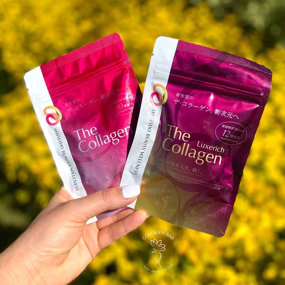 Упаковки з колагеном SHISEIDO Beauty Wellness The Collagen і SHISEIDO Beauty Wellness The Collagen Luxerich у жіночій руці з білим манікюром на тлі куща в розфокусі