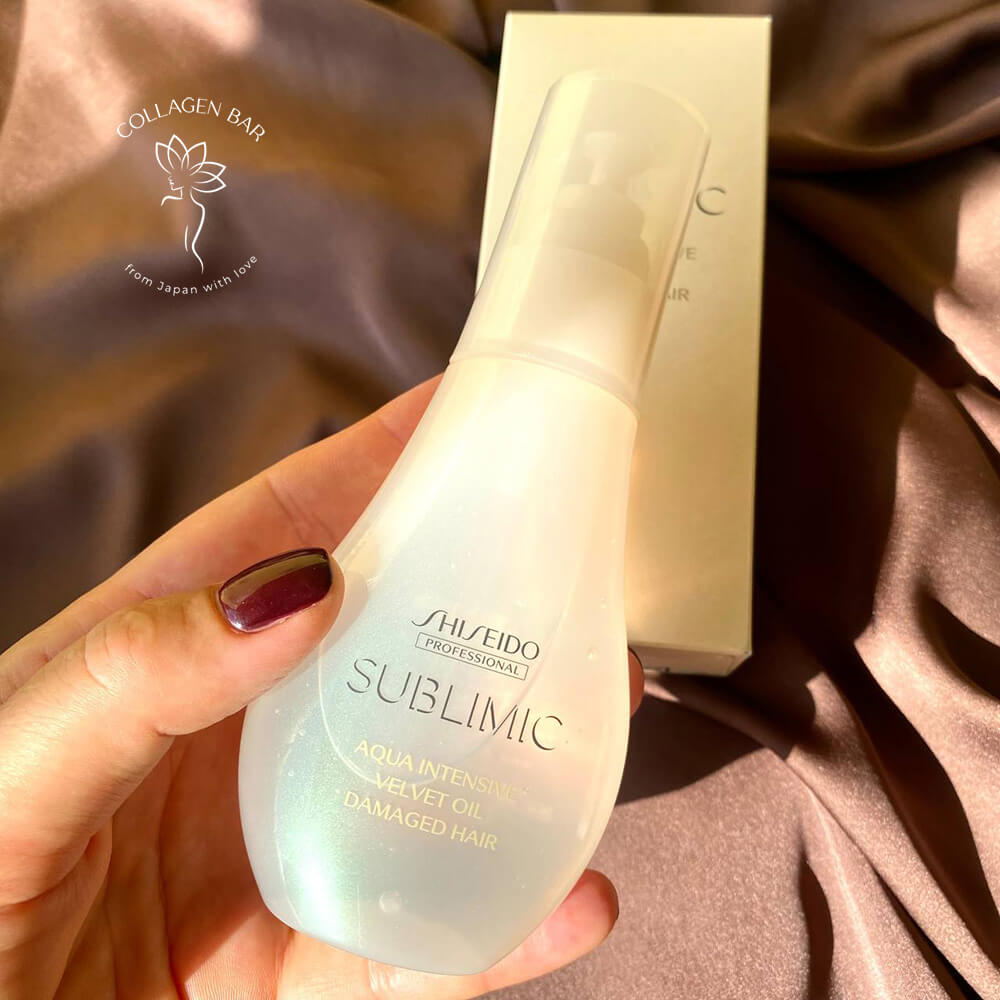 Олія для волосся SHISEIDO SUBLIMIC Velvet OIL у жіночій руці над коричневою тканиною